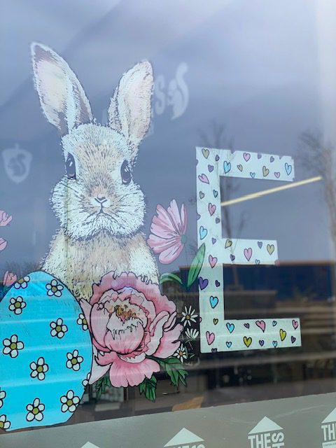 Hand‑painted Egg Hunt trail window mural featuring hidden letters for a family puzzle across local shops.