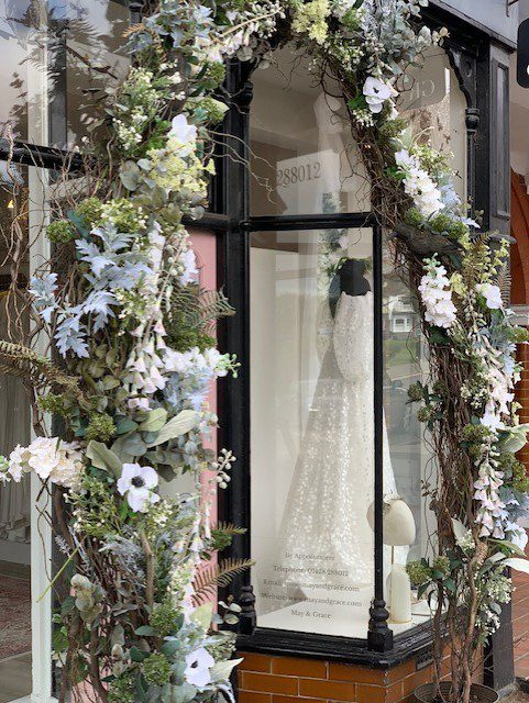 Completed faux‑flower wreath installation for May & Grace boutique, shown from the street in Haslemere, Surrey.